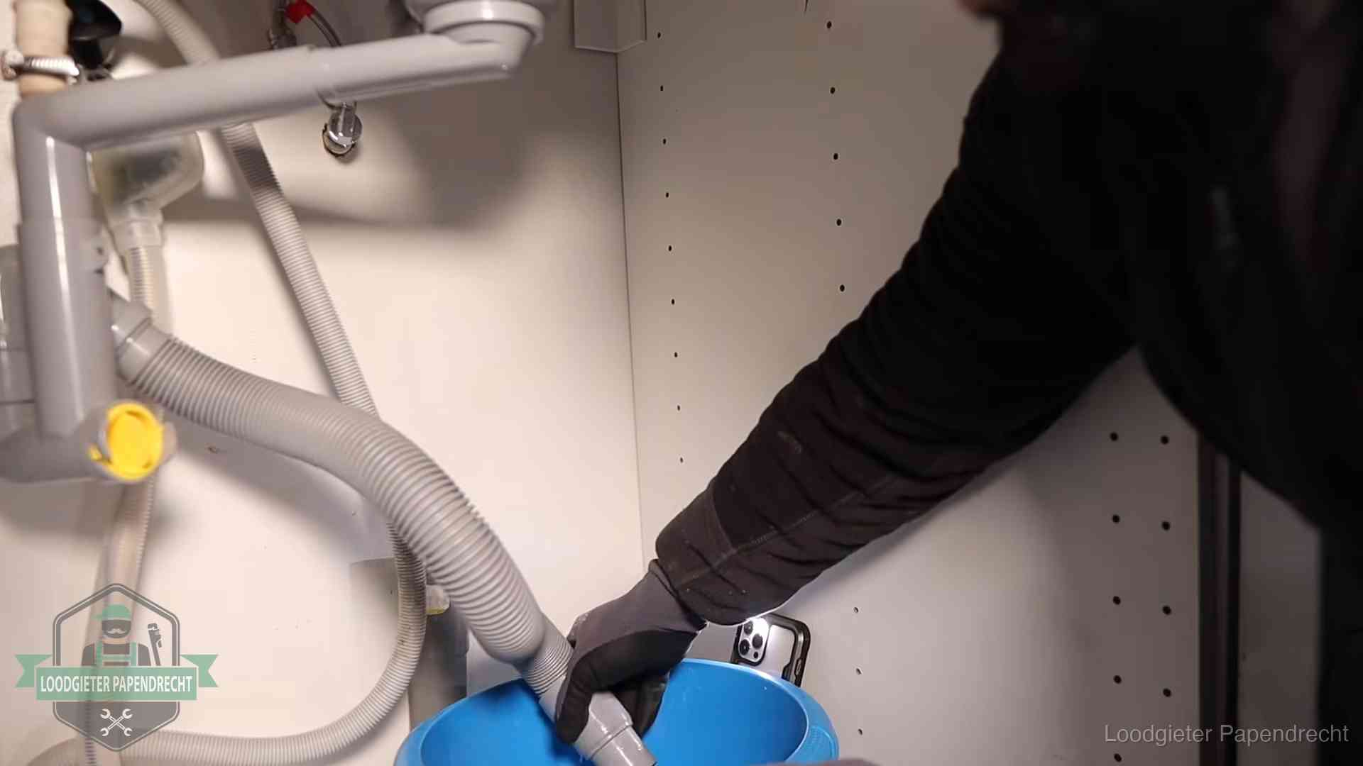Afvoerslang loopt leeg in een emmer onder de gootsteen in Papendrecht, een klus die je zelf kunt doen