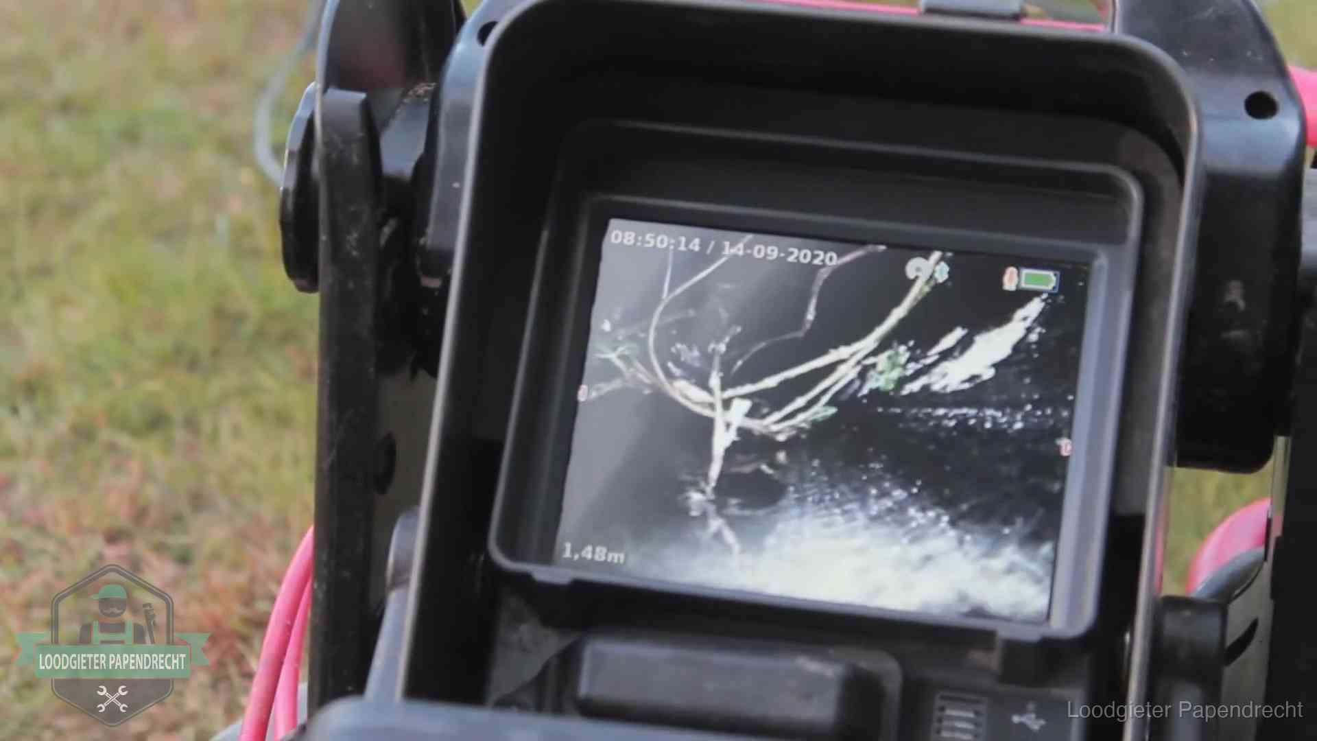 Monitor van een rioolcamera toont wortelingroei in de rioolbuis bij een woning in Papendrecht