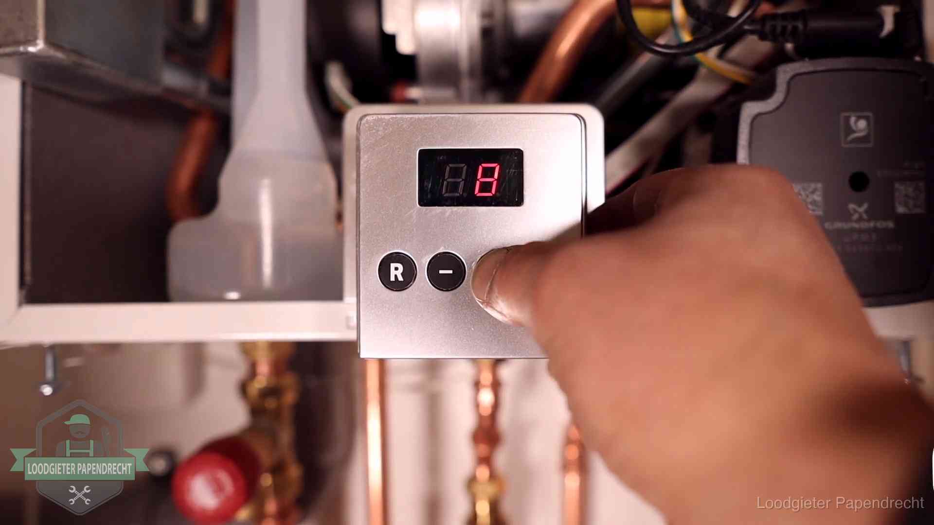 Monteur bedient het display van een cv-ketel bij een storing in Papendrecht