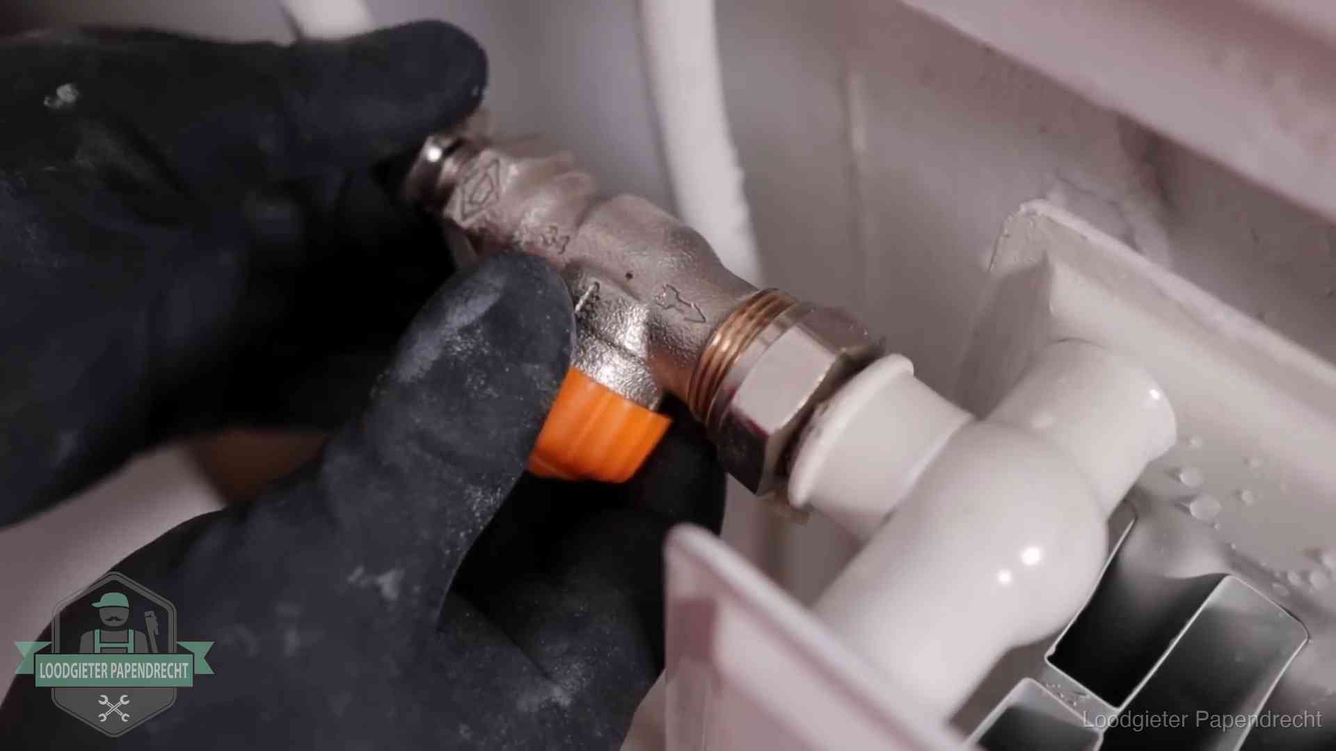 Thermostaatkraan wordt gemonteerd op een radiator in Papendrecht voor het stookseizoen