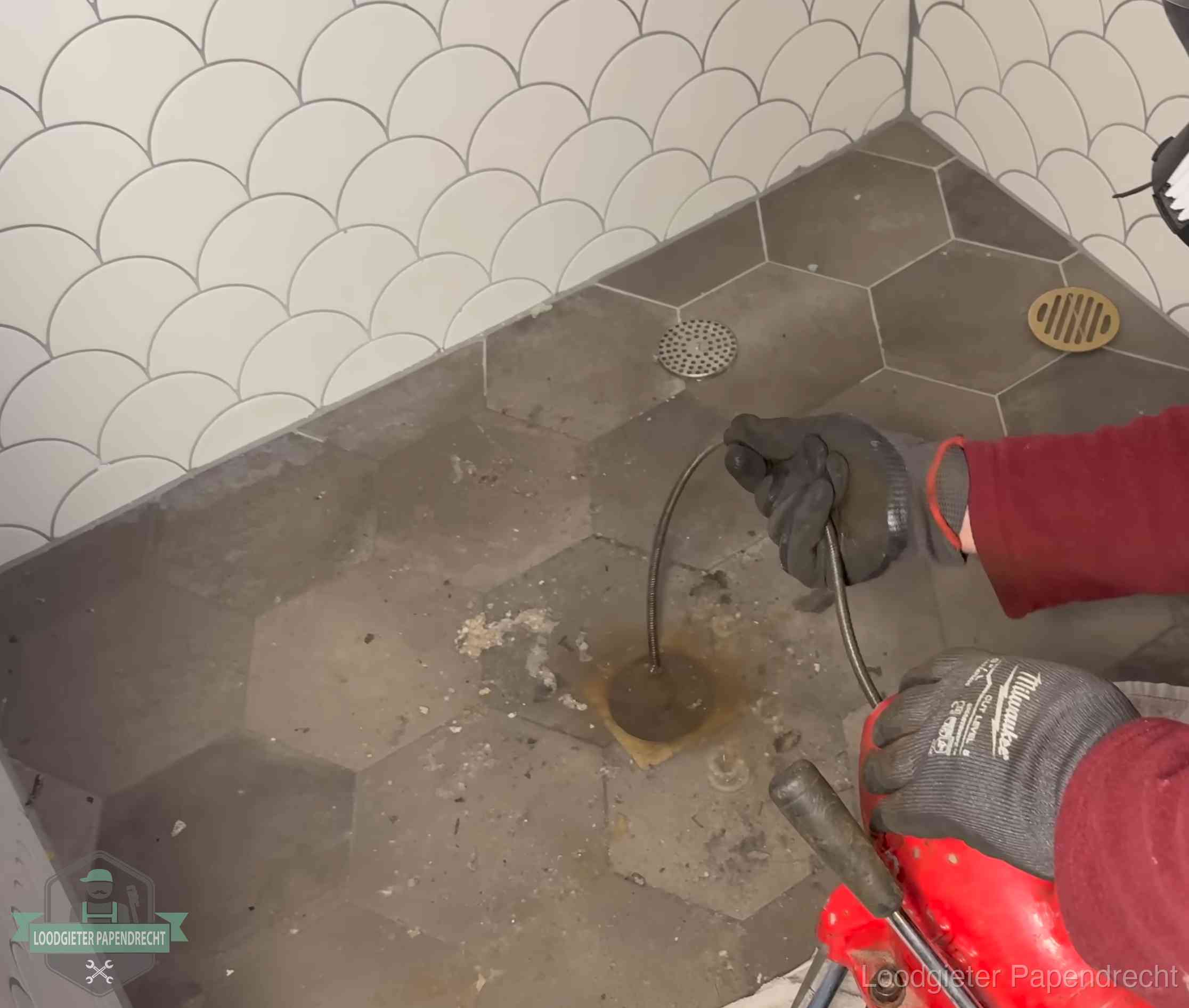 Ontstoppingsveer gaat in een geopend doucheputje in Papendrecht waar het water omhoogkwam