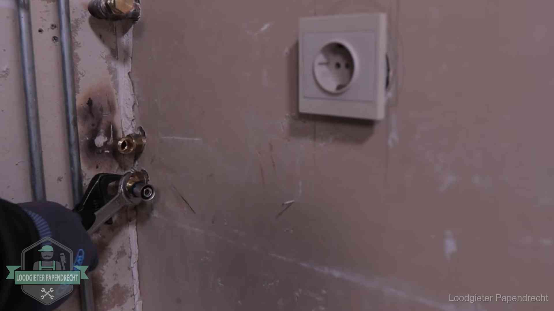 Monteur draait een perskoppeling vast op een leidingaansluiting in Papendrecht