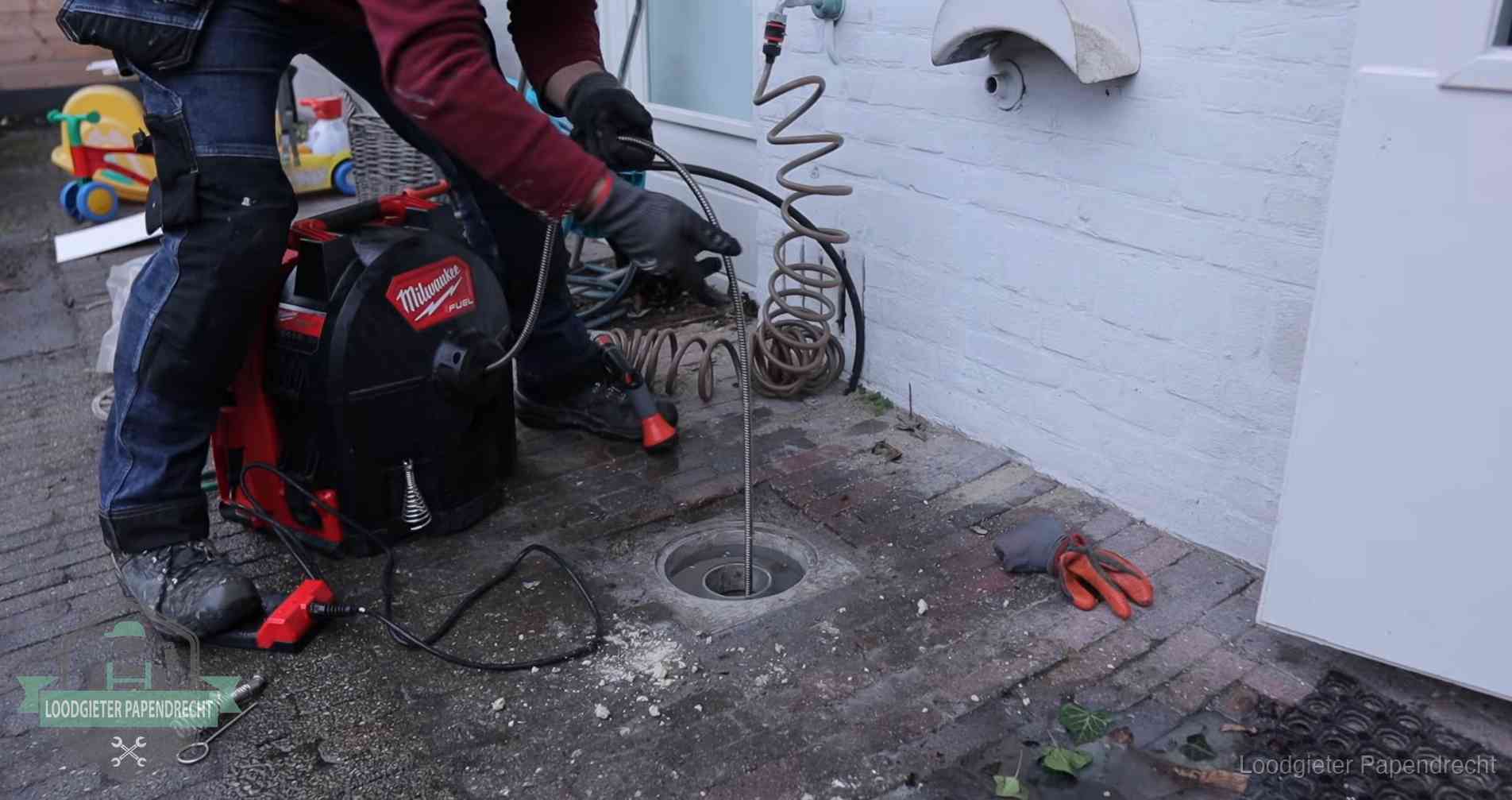 Ontstoppingsputje in de bestrating naast de gevel van een woning in Papendrecht