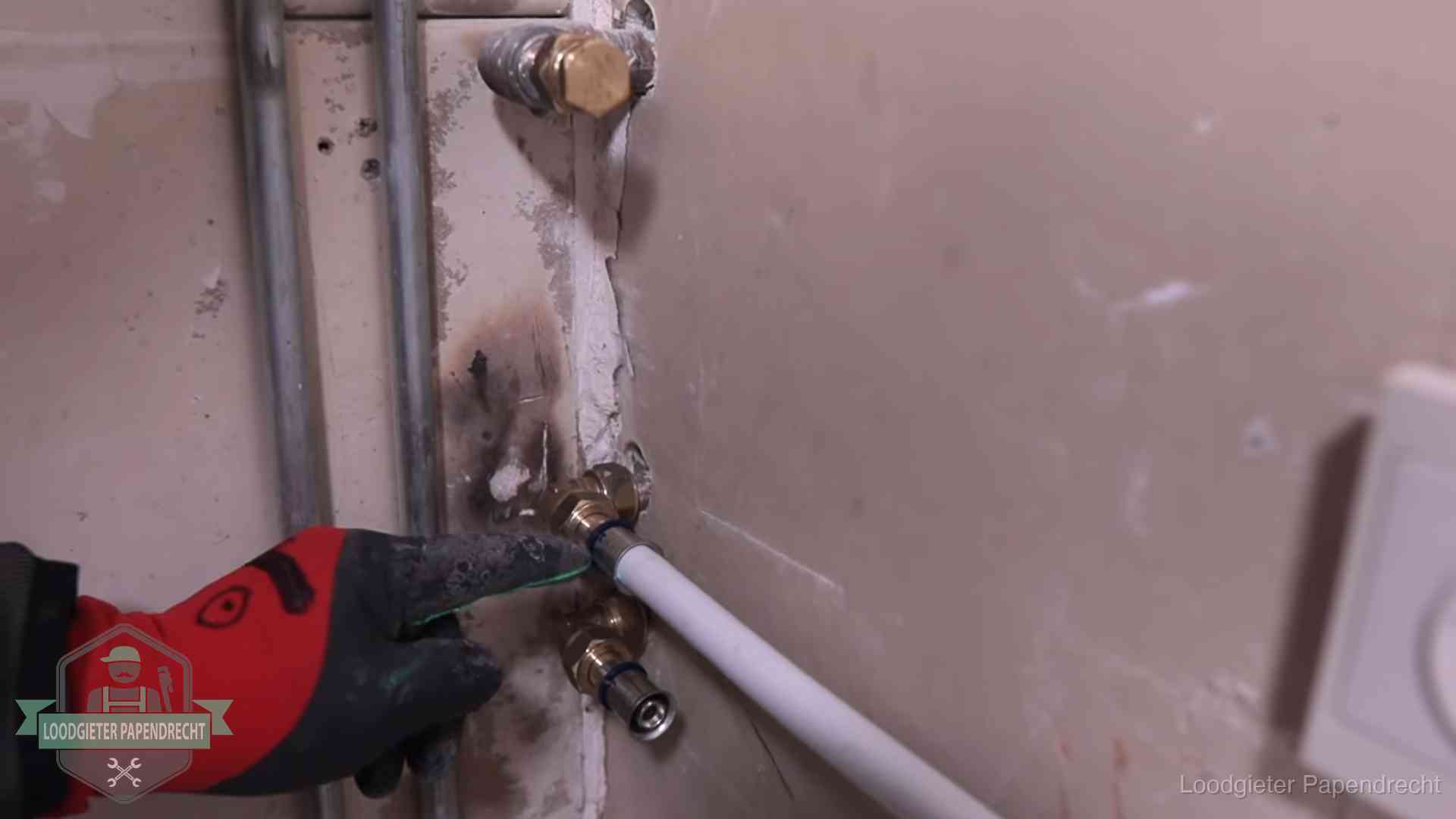 Loodgieter wijst de persfitting op nieuwe muuraansluitingen aan in een woning in Papendrecht
