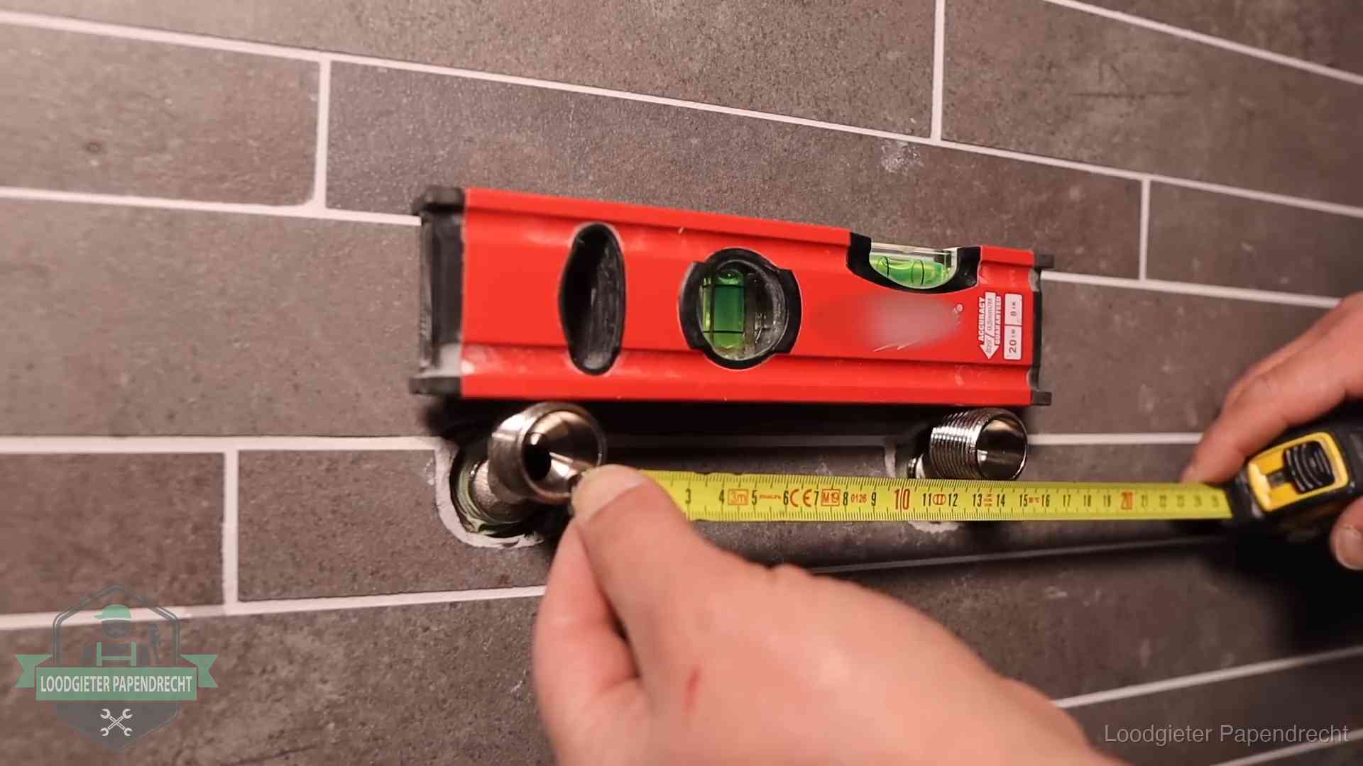 Waterpas en duimstok bij kraan-aansluitpunten in een badkamer in Papendrecht