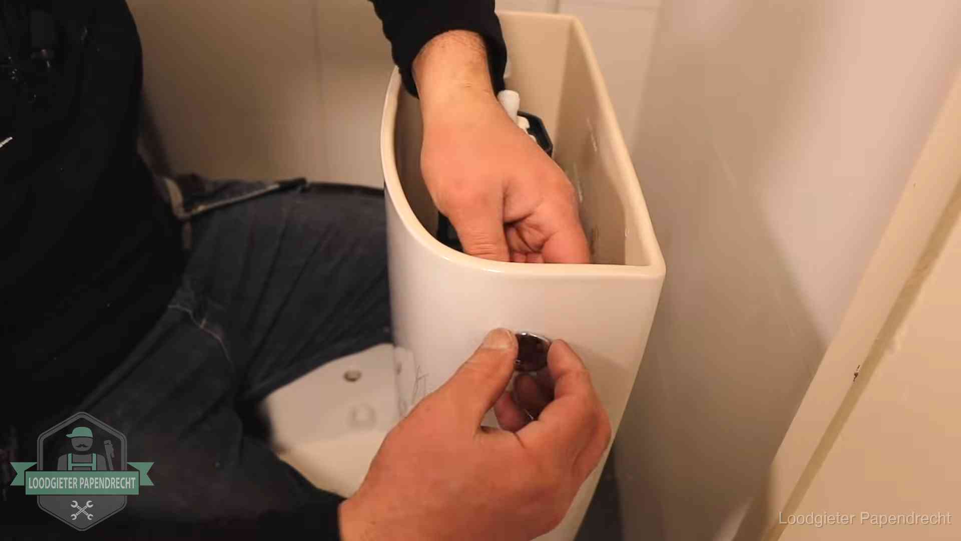 Je wc verstoppingsvrij houden in Papendrecht Drukknop van een duoblok-stortbak wordt gemonteerd bij een toilet in Papendrecht