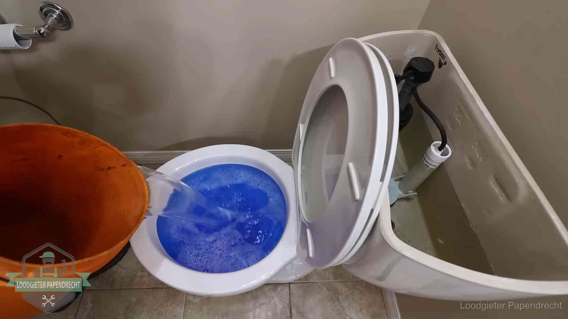 Water komt omhoog in de wc in Papendrecht Water bij de wc-pot wordt met een emmer weggewerkt om schade te beperken in Papendrecht
